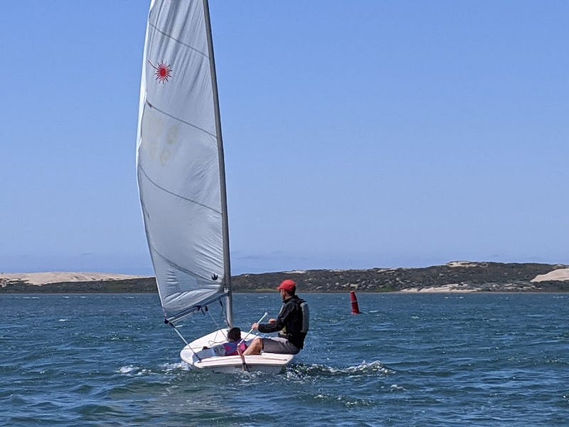 A father and small daughter sailing a small boat